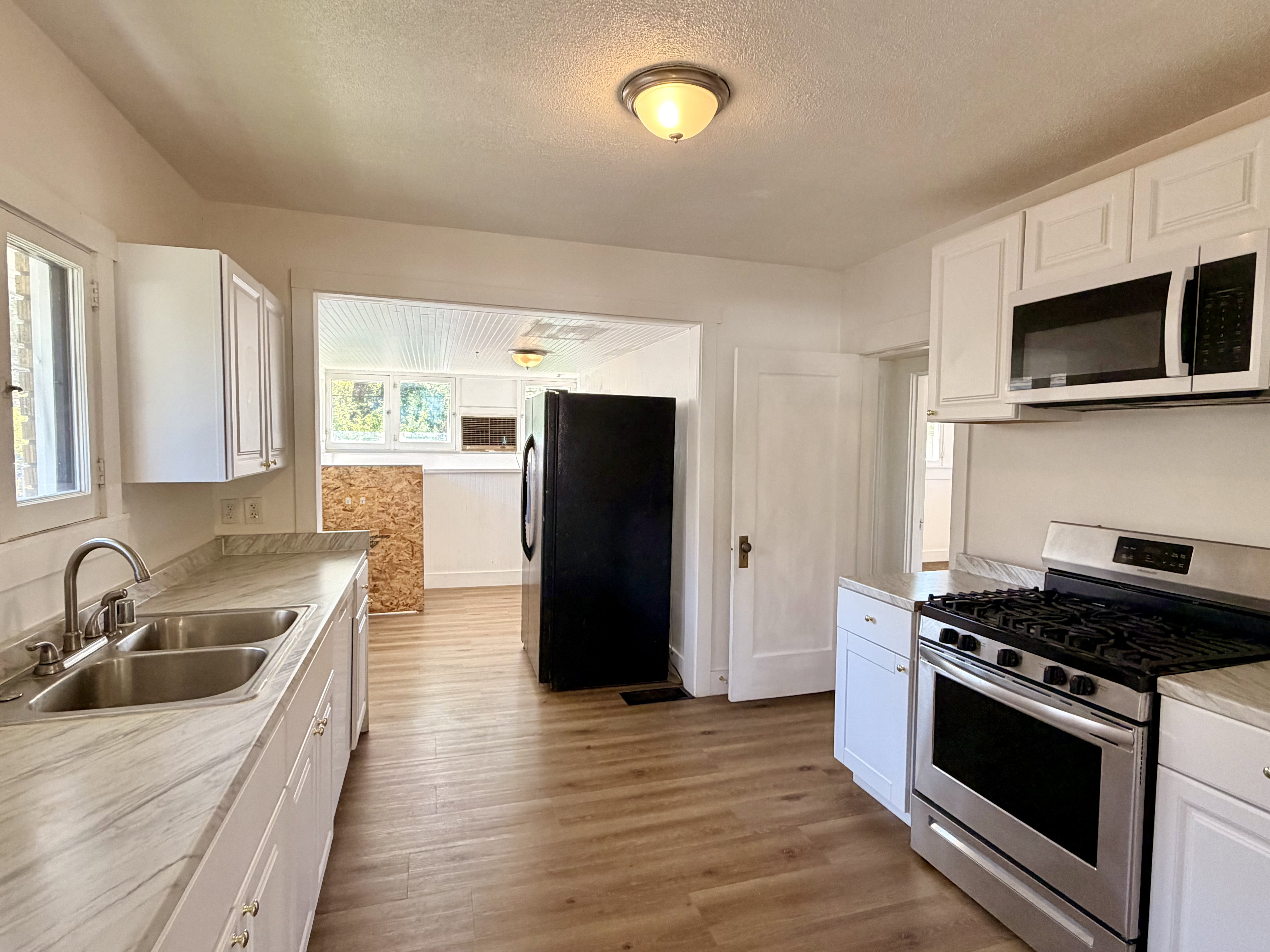 Kitchen featuring white cabinetry, light wood-finish flooring, and light-colored countertops