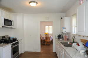 Kitchen featuring white appliances, light countertops, and white cabinets