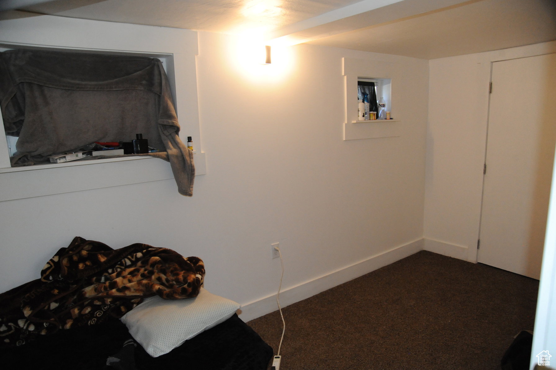 Bedroom featuring dark colored carpet and baseboards