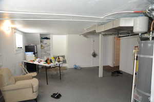 Below grade area with secured water heater and freestanding refrigerator