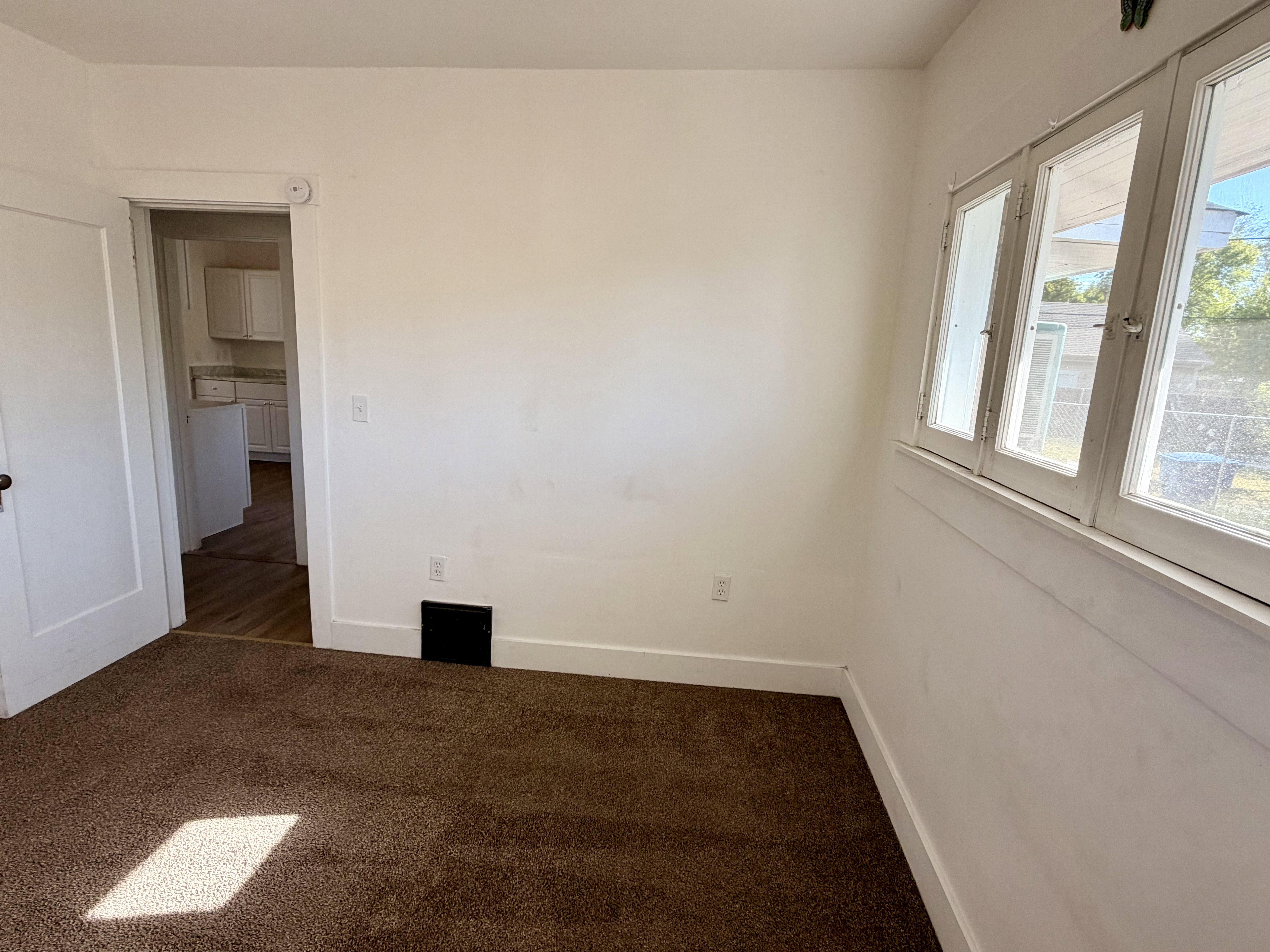 Room featuring brown carpet flooring, white walls, and a multi-pane window