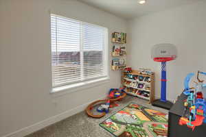 Playroom with baseboards and carpet floors