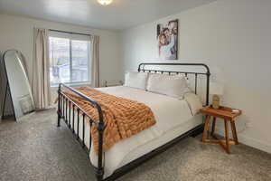 Bedroom with baseboards and light carpet