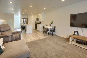 Living area with recessed lighting and light wood-type flooring