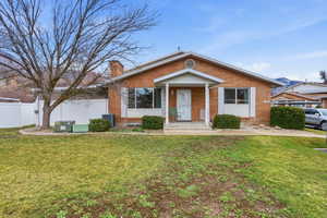 Bungalow-style home with brick siding and a chimney