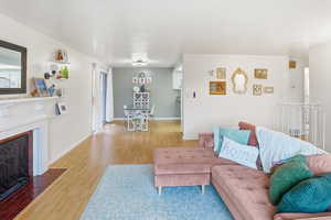 Living room featuring light wood-style flooring and a fireplace with flush hearth