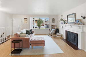 Living area with light wood-style flooring and a fireplace