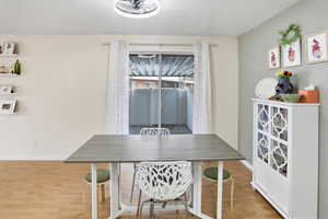 Dining area featuring light wood finished floors and a textured ceiling