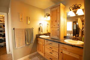 Full five piece bathroom featuring a double vanity, a walk in closet, and a jetted garden tub.
