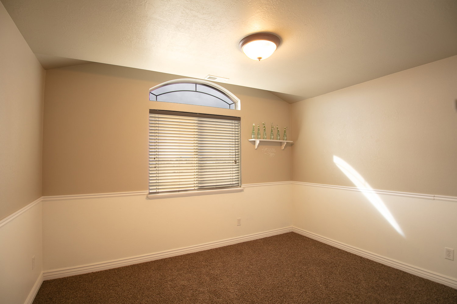 Large upstairs bedroom with an arched window.