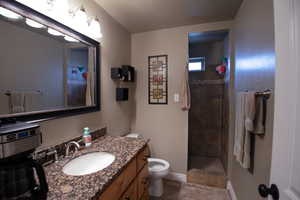 Downstairs 3/4 bath featuring vanity and tiled shower.