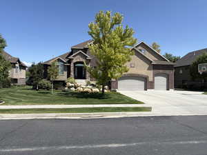 Craftsman-style home featuring concrete driveway, front lawn, and brick siding