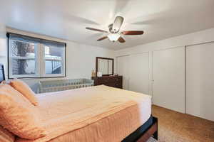 Bedroom featuring two closets, carpet floors, and ceiling fan