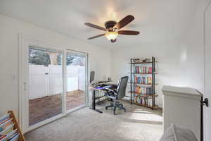 Office with light carpet and a ceiling fan