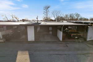 View of parking with an attached carport and driveway