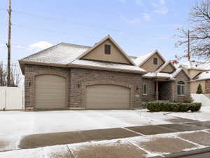 View of front of house featuring stucco siding, stone siding, an attached garage, and concrete driveway