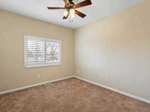 Empty room with carpet flooring and ceiling fan
