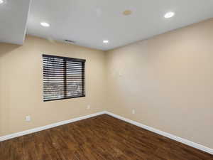 Spare room featuring dark wood-style flooring and recessed lighting