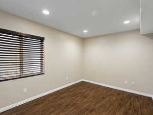 Spare room featuring dark wood-style flooring and recessed lighting