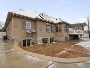 Rear view of property with solar panels and stucco siding