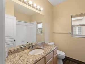 Bathroom featuring vanity, wood finish floors, and a shower