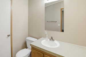 Half bathroom featuring vanity and toilet