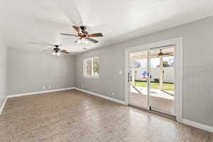 Spare room with a ceiling fan, light wood finished floors, and a textured ceiling