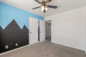 Unfurnished bedroom with carpet, a textured ceiling, and ceiling fan