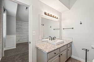 Full bathroom with vanity and dark carpet