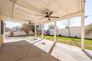 Fenced backyard featuring a patio area and ceiling fan