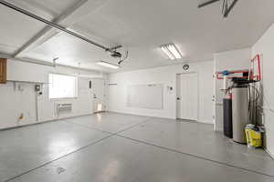 Garage featuring baseboards and an AC wall unit