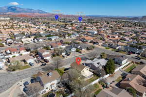 Aerial view of property and surrounding area featuring a mountain backdrop and nearby suburban area
