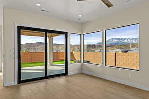 Unfurnished sunroom featuring a mountain view, wood finished floors, and recessed lighting