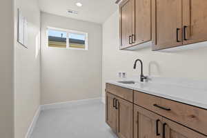 Laundry area with cabinet space, hookup for a washing machine, and recessed lighting