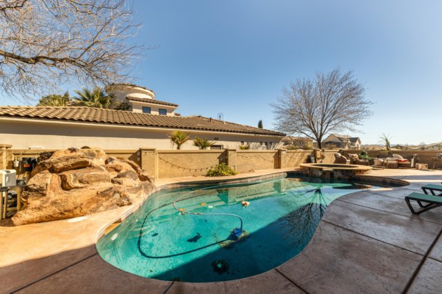 Integrated pool / spa with a patio area and a fenced backyard