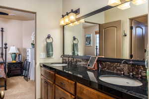 Bathroom featuring double vanity, light carpet, and connected bathroom