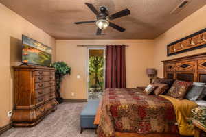 Bedroom with access to outside, carpet, a ceiling fan, and a textured ceiling