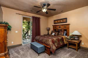Bedroom featuring access to outside, ceiling fan, carpet, and a textured ceiling