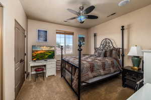 Carpeted bedroom with ceiling fan and an office area