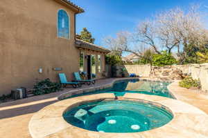 Combined pool / hot tub featuring a fenced backyard and a patio