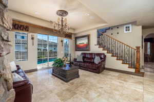 Living room featuring arched walkways, a tray ceiling, and hanging lights