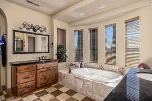 Full bath featuring two vanities, a garden tub, and recessed lighting