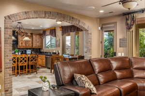 Living room featuring arched walkways, recessed lighting, and ceiling fan