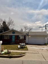 Single story home featuring driveway, a garage, a front yard, and roof with shingles