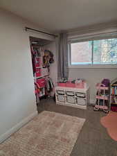 Bedroom featuring dark carpet and baseboards