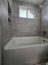 Full bath with tub / shower combination and tile patterned flooring