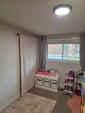 Bedroom featuring dark carpet and baseboards