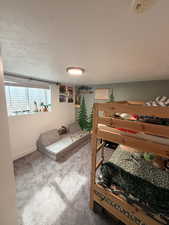 Bedroom with a textured ceiling and carpet