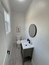 Half bath with vanity and light wood-style floors