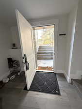 Doorway to outside with stairway and wood finished floors